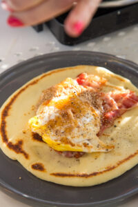 Herzhafte Pfannkuchen zum Fr&uuml;hst&uuml;ck: mit Honig-Sesam-Ei und knusprigem Bacon – ein kreativer Start in den Tag, der s&uuml;&szlig; und salzig perfekt vereint!