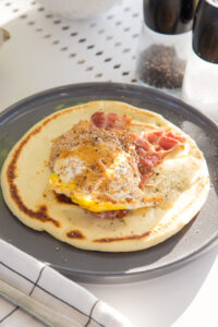 Herzhafte Pfannkuchen zum Fr&uuml;hst&uuml;ck: mit Honig-Sesam-Ei und knusprigem Bacon – ein kreativer Start in den Tag, der s&uuml;&szlig; und salzig perfekt vereint!