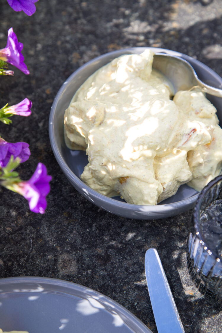 Zitroniges Sommerhühnchen in cremiger Curry-Joghurt-Marinade, serviert mit Brot auf einem sommerlich gedeckten Tisch