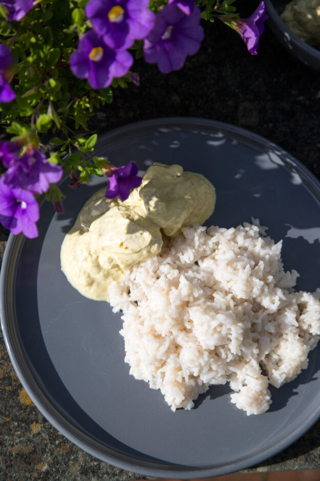 Zitroniges Sommerhühnchen in cremiger Curry-Joghurt-Marinade, serviert mit Brot auf einem sommerlich gedeckten Tisch