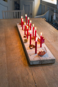 Ein einfaches DIY-Kerzenbrett aus Holz: Bohrt kleine L&ouml;cher f&uuml;r Tannenbaumkerzen und dekoriert es immer wieder neu – perfekt f&uuml;r Herbst & Weihnachten!