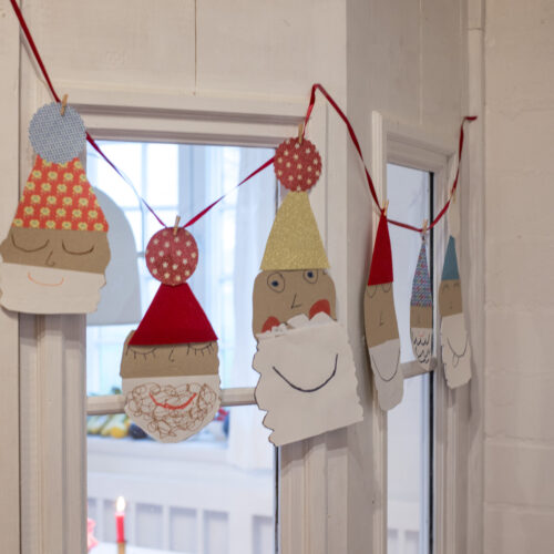 Zaubert eine niedliche Weihnachtsmann-Girlande aus bunten Papieren! Einfaches DIY für Kinder & Erwachsene, perfekt für Fenster, Türen oder den Tannenbaum.