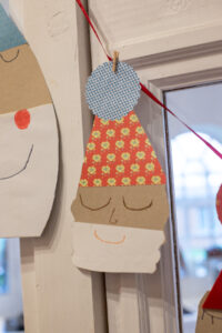 Zaubert eine niedliche Weihnachtsmann-Girlande aus bunten Papieren! Einfaches DIY f&uuml;r Kinder & Erwachsene, perfekt f&uuml;r Fenster, T&uuml;ren oder den Tannenbaum.