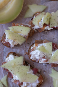 Knuspriges Grillbrot mit Frischkäse, Schinken, orangener Melone und Burrata – ein schnelles, raffiniertes Rezept für Brunch oder Sommerabende.